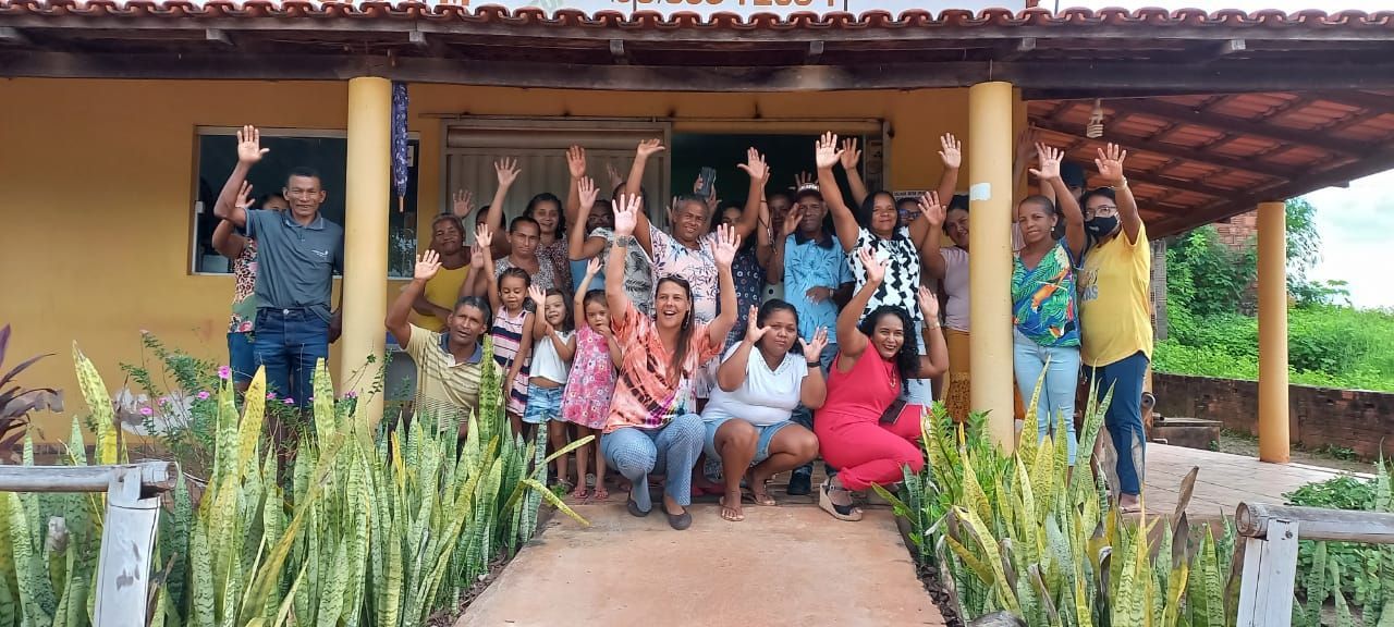 Um grupo de pessoas está posando para uma foto em frente a uma casa.
