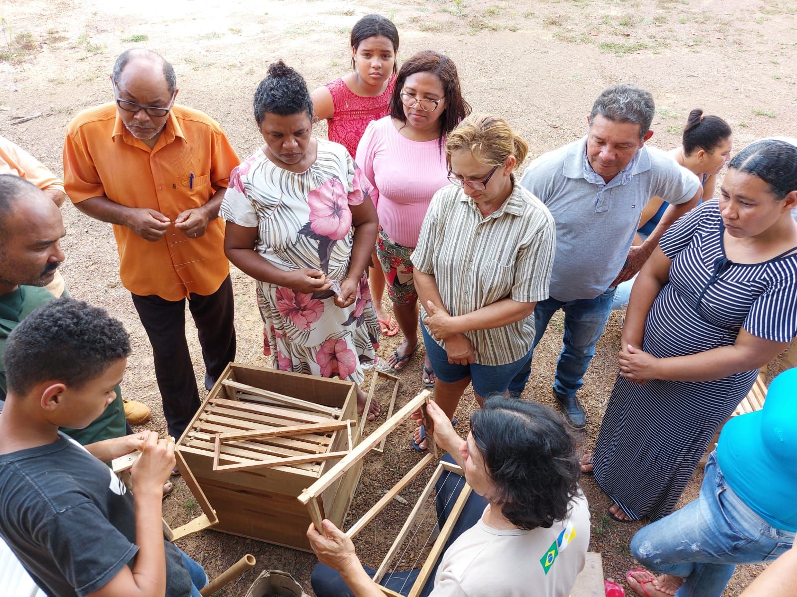 Um grupo de pessoas está em pé ao redor de uma estrutura de madeira.