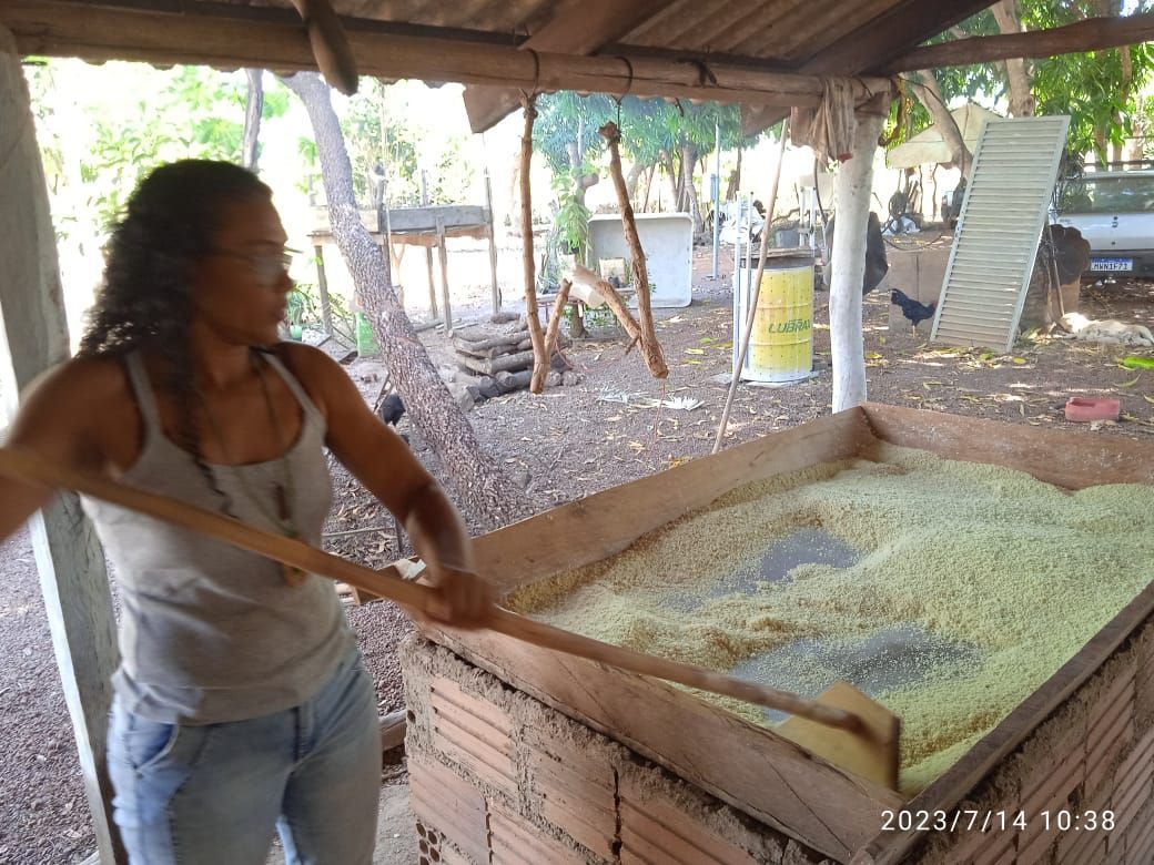 Uma mulher está usando uma colher de pau para mexer uma grande pilha de comida.