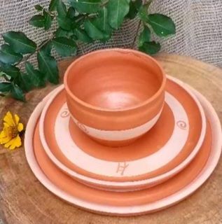 Uma tigela e pratos empilhados uns sobre os outros sobre uma mesa de madeira.