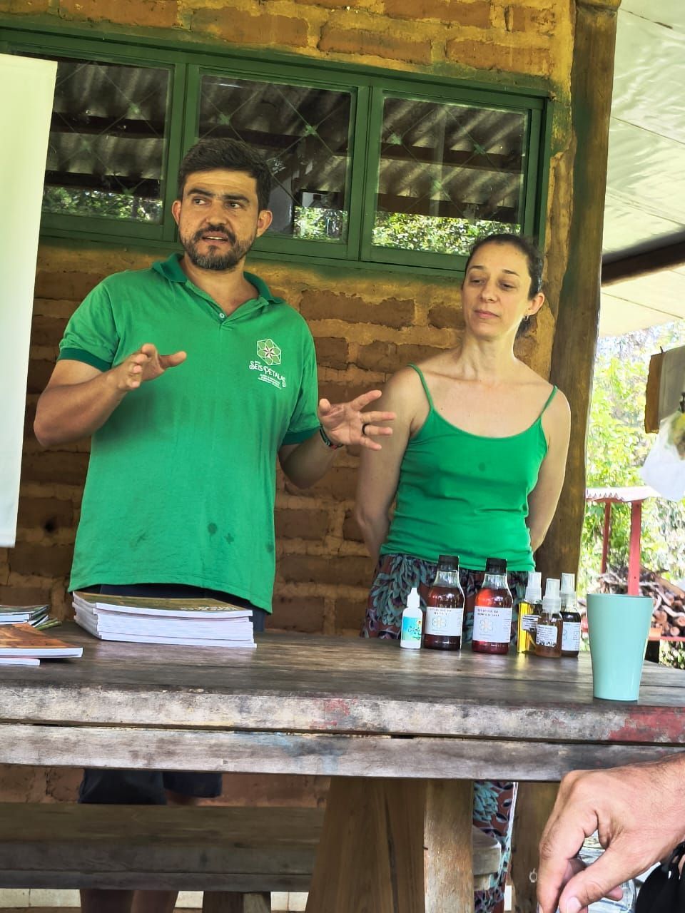 Um homem de camisa verde está parado ao lado de uma mulher de blusa verde