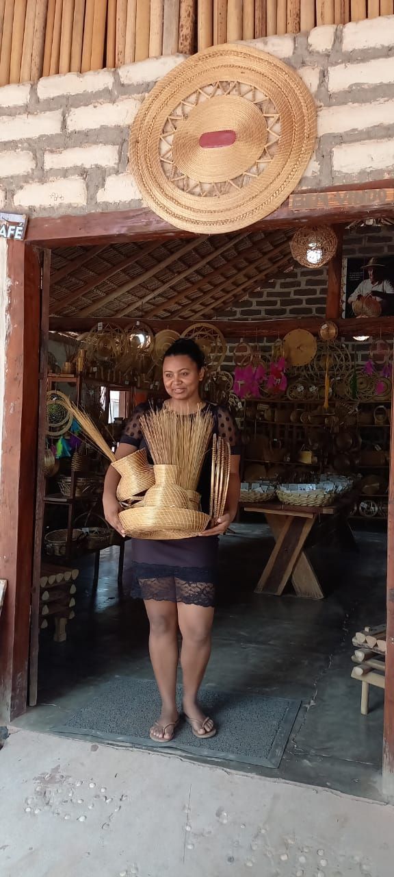 Uma mulher está parada em frente a um prédio segurando uma bandeja de comida.