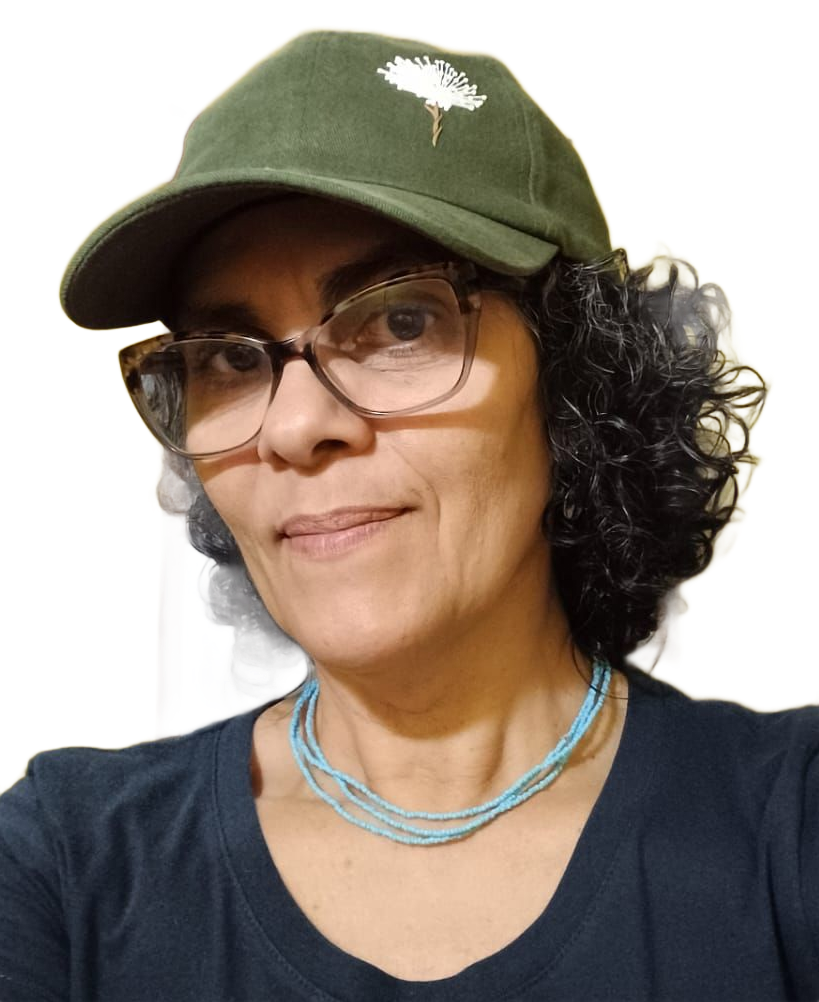 Uma mulher de óculos e camisa verde olha para a câmera