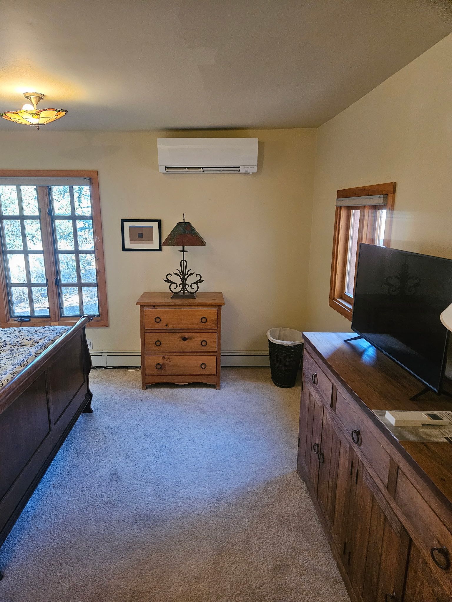 Bedroom with wooden furniture, tan walls, and a window.