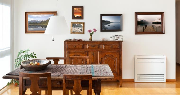 Dining room with a wooden table and chairs, a sideboard with artwork, and a white air conditioner.