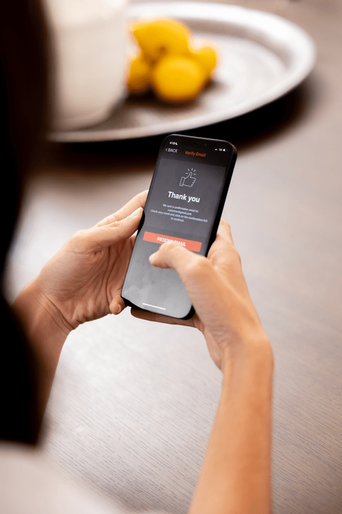 Person holding a smartphone; the screen displays a 