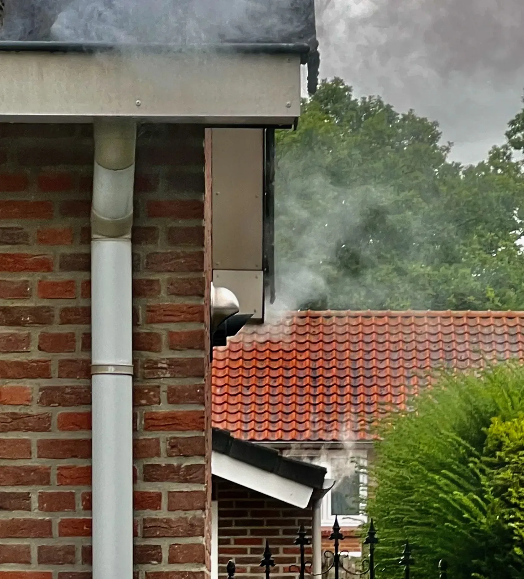 Tijdens rooktest komt witte rook uit regenwaterafvoer zonder sifon – teken van open rioolverbinding