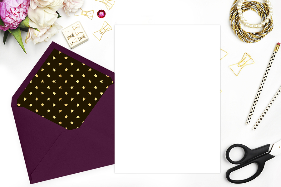 Purple envelope with gold star patterned lining and blank white paper, florals and stationery.