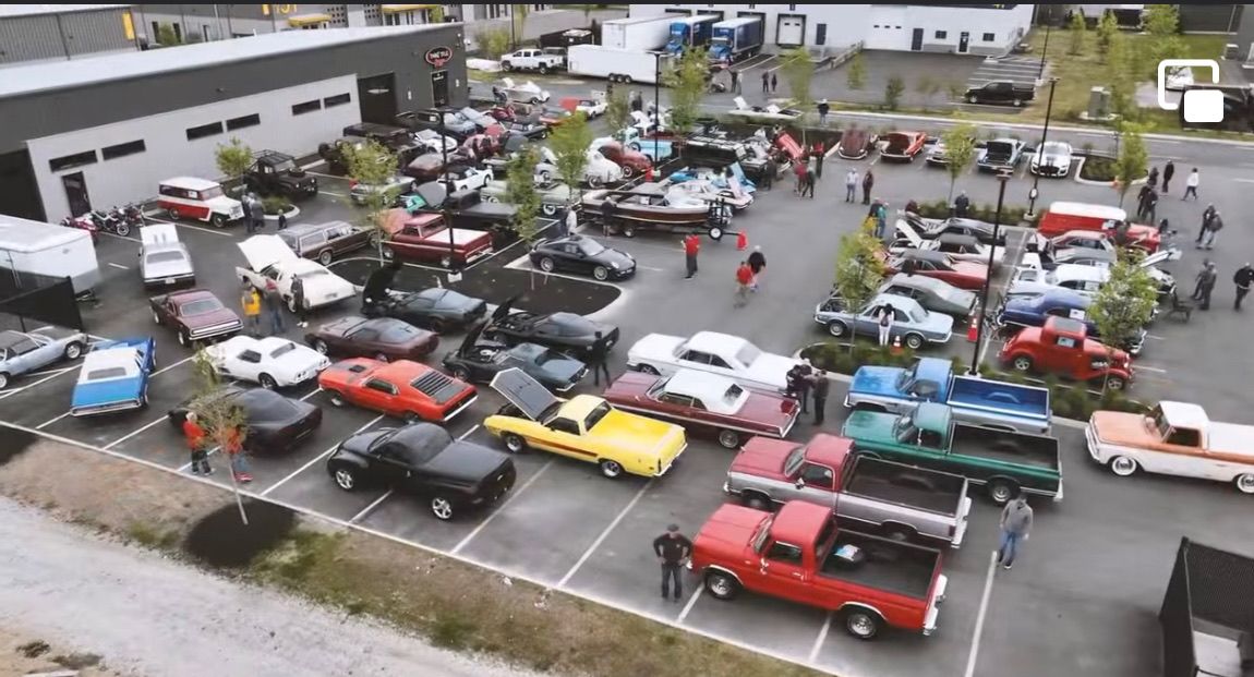 An aerial view of a parking lot filled with cars and trucks