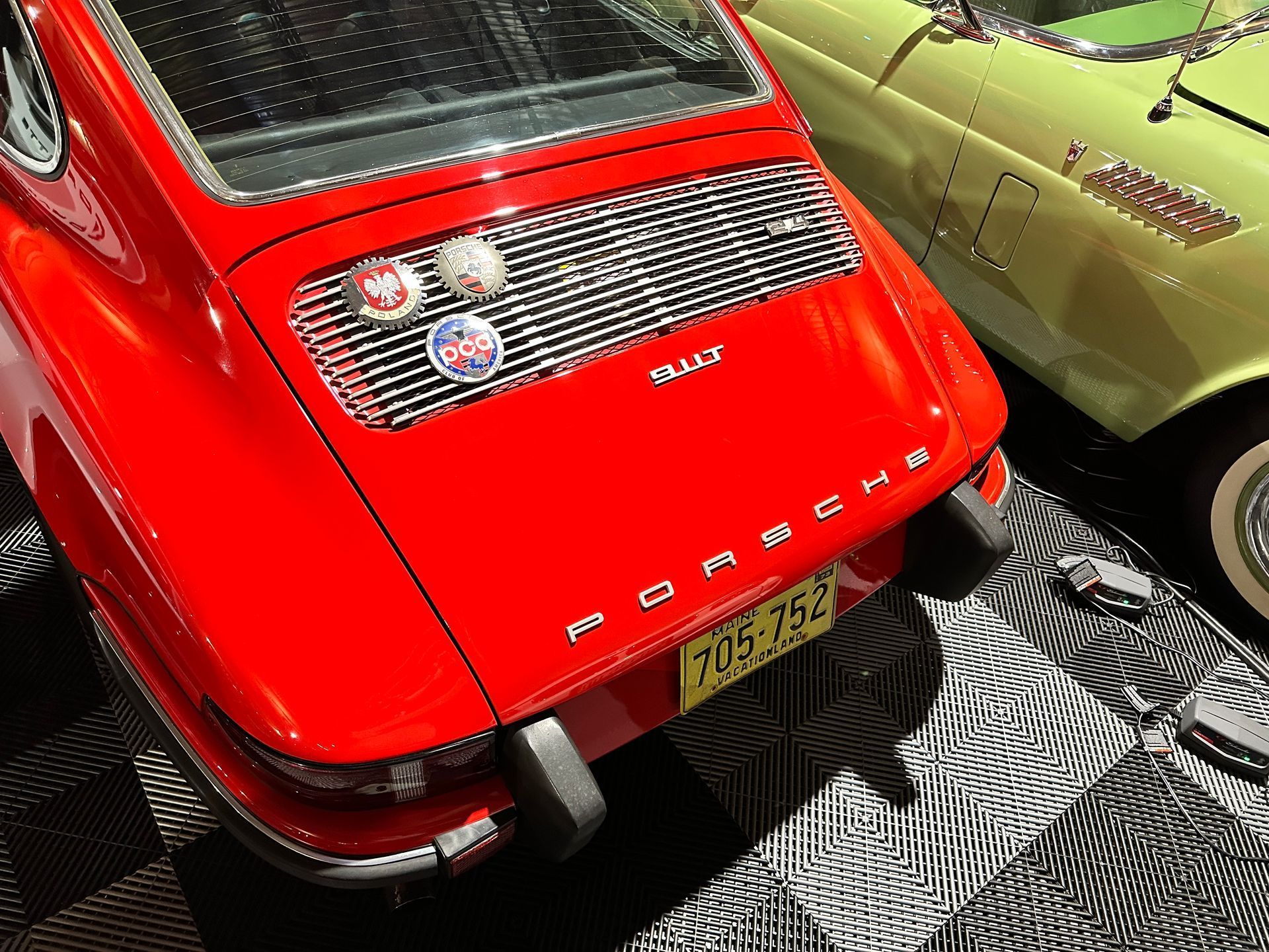 A red porsche is parked next to a yellow car