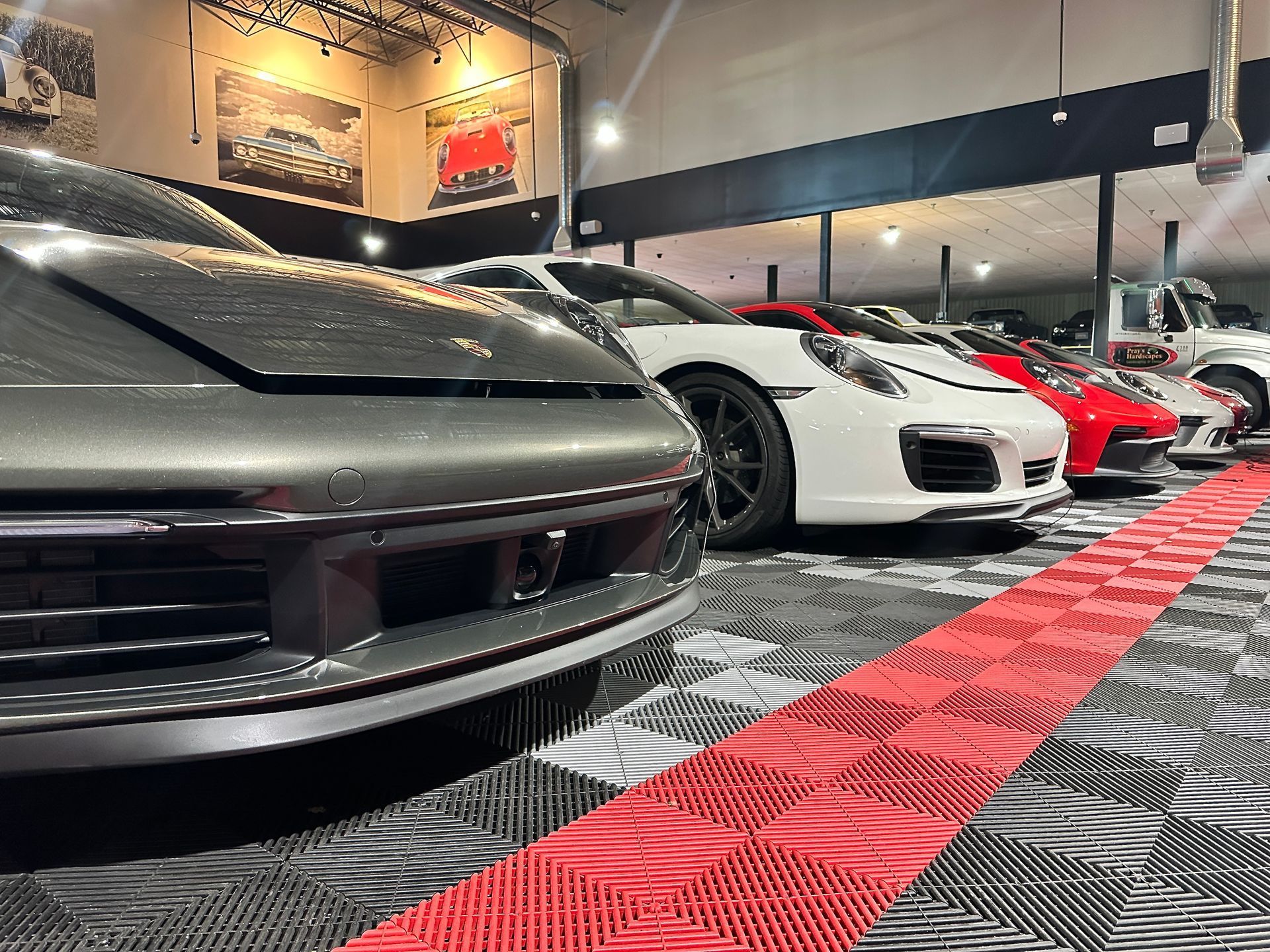 A row of sports cars are parked in a showroom.