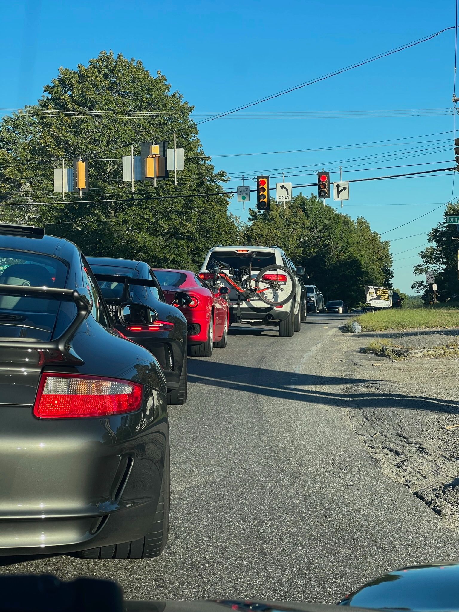 A row of cars are driving down a highway.