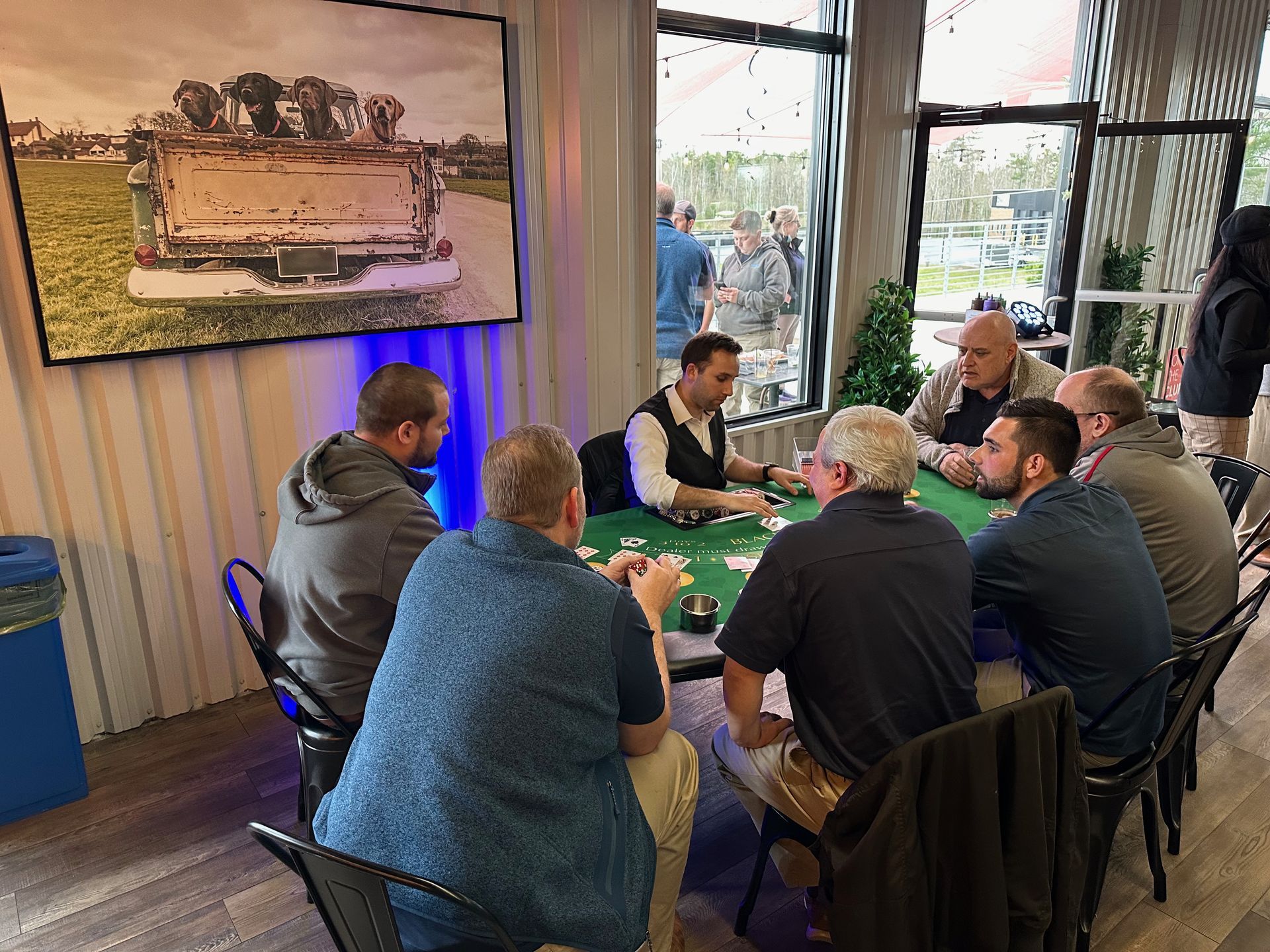 A group of men are sitting around a table playing cards.