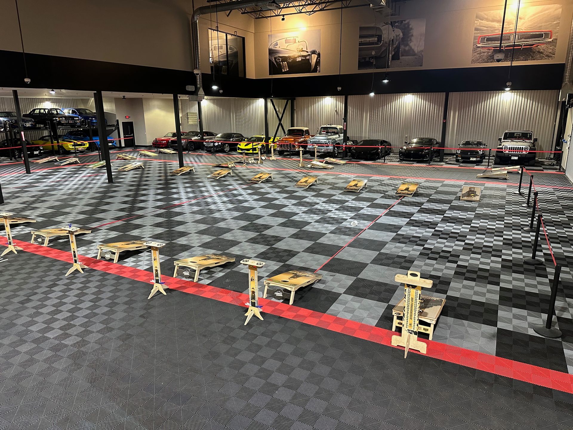 A large room with a checkered floor and a lot of cars in it.