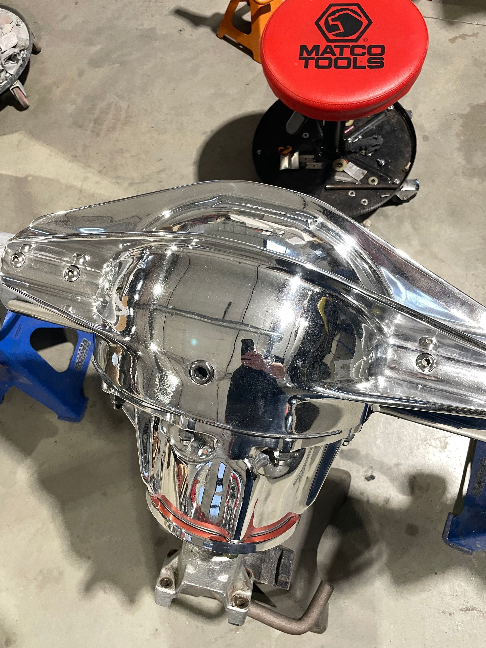 A red master force stool is sitting on top of a chrome object.