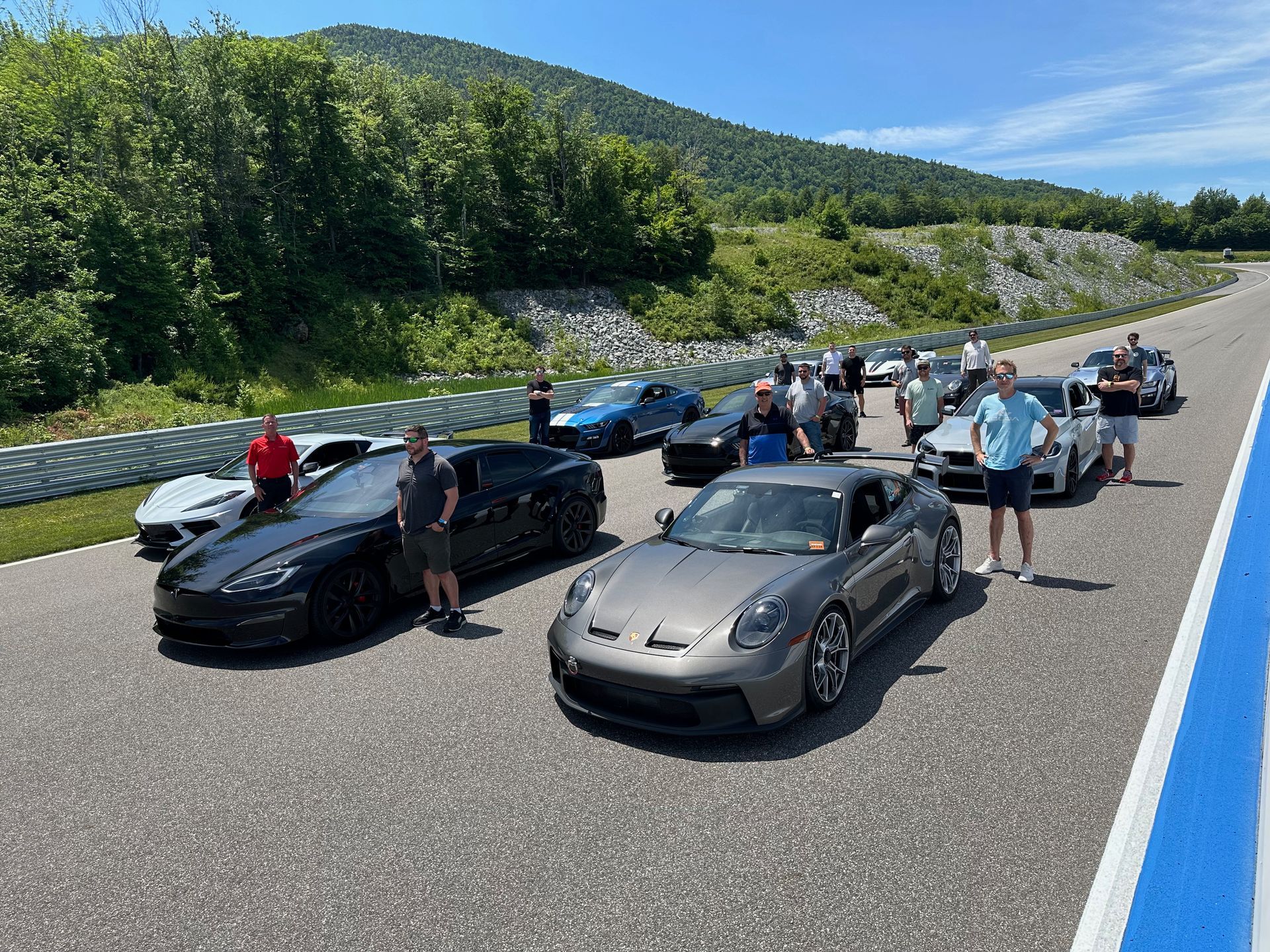 A group of cars are parked on the side of a road.