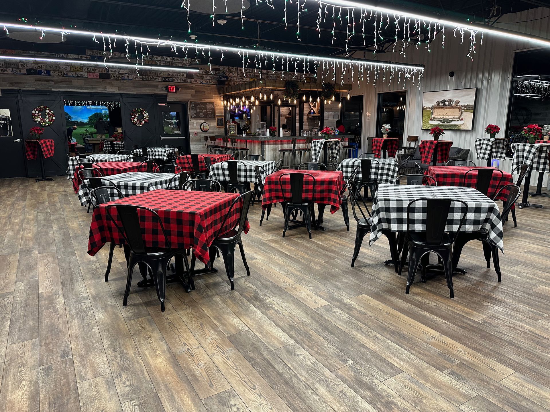 A large room filled with tables and chairs with plaid tables cloths.