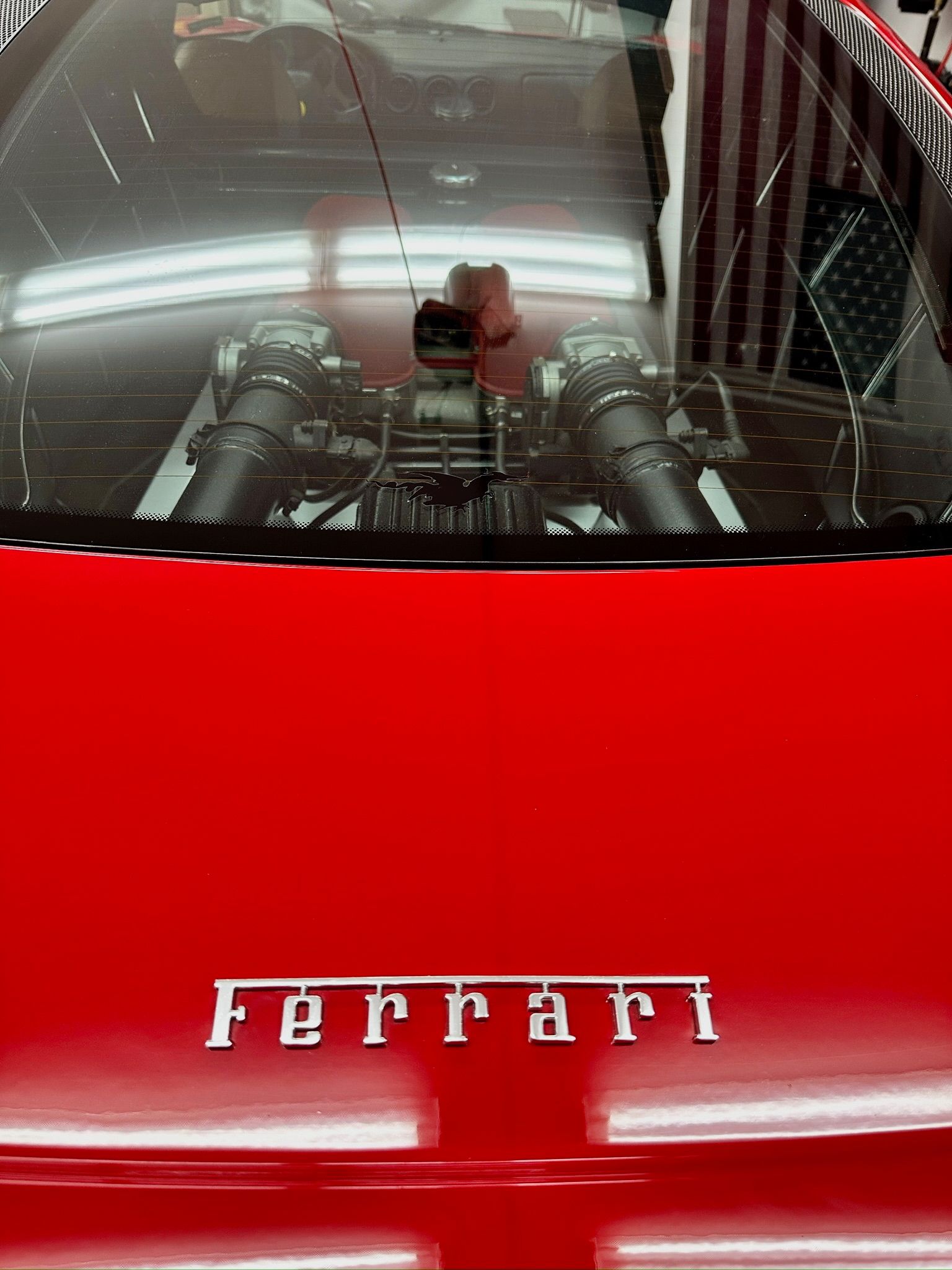 A close up of the hood of a red ferrari
