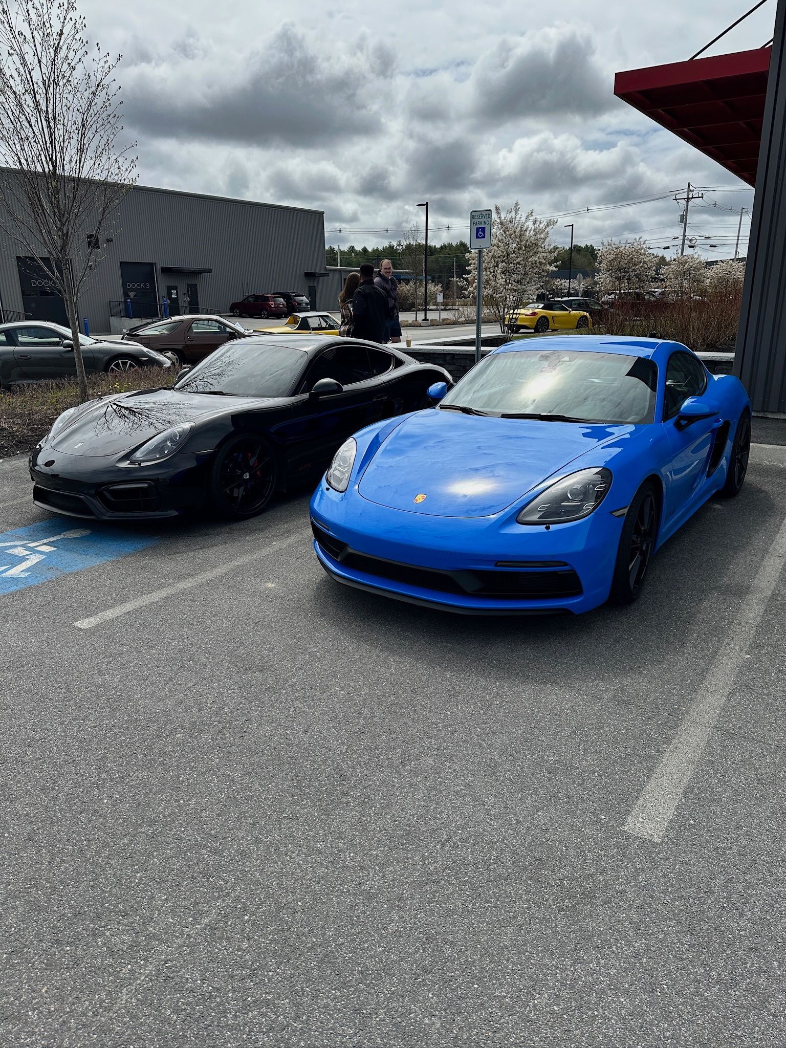 Two sports cars are parked next to each other in a parking lot.