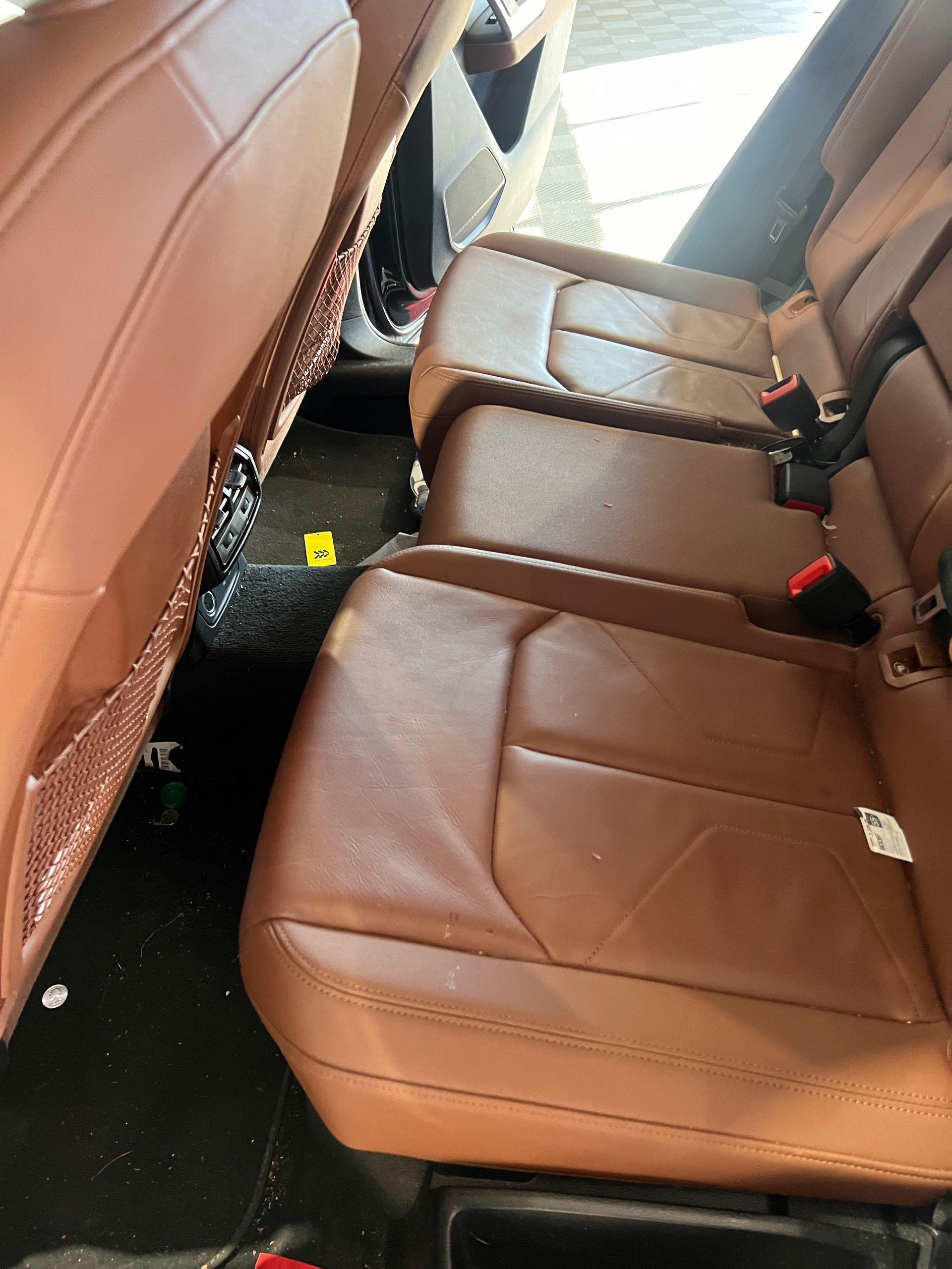 The back seat of a car with brown leather seats.