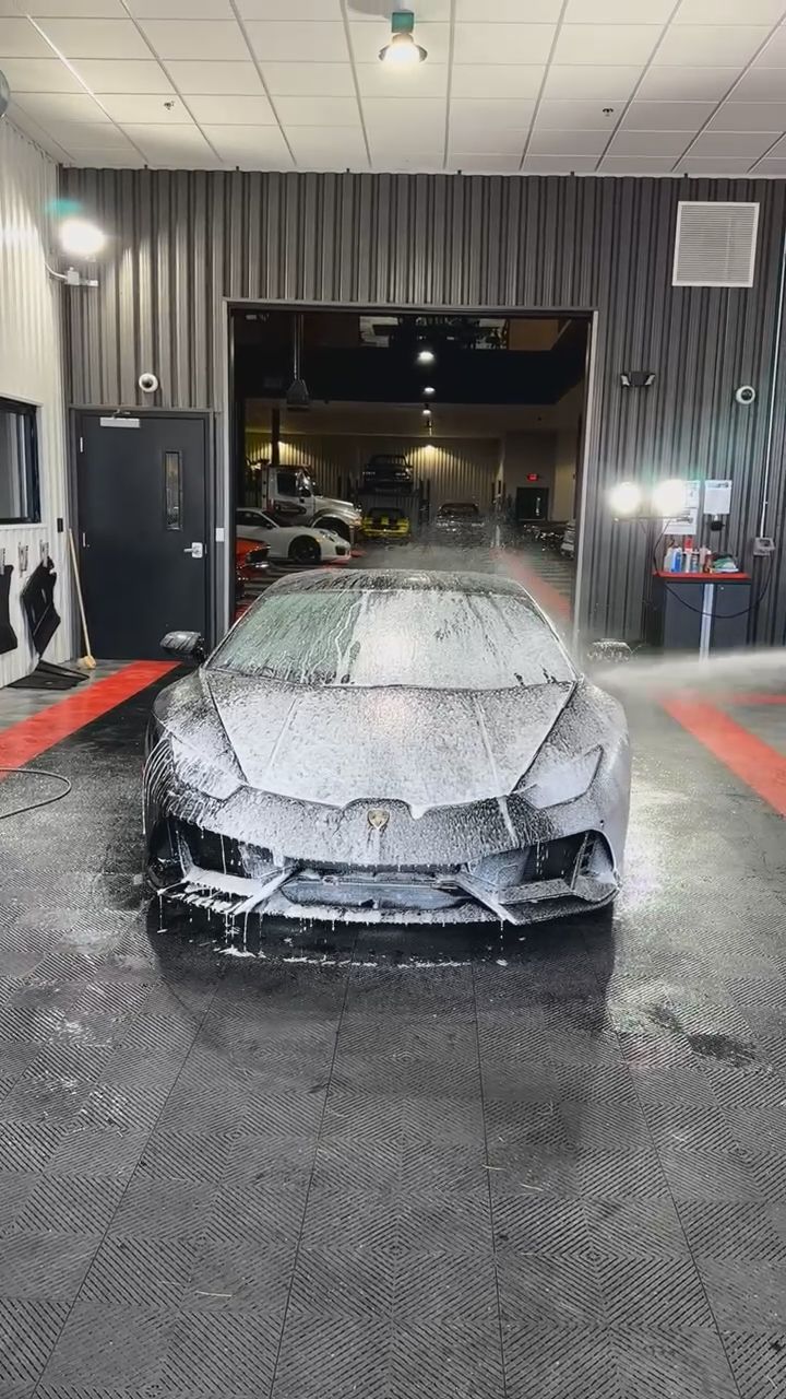 A car is covered in foam in a garage.