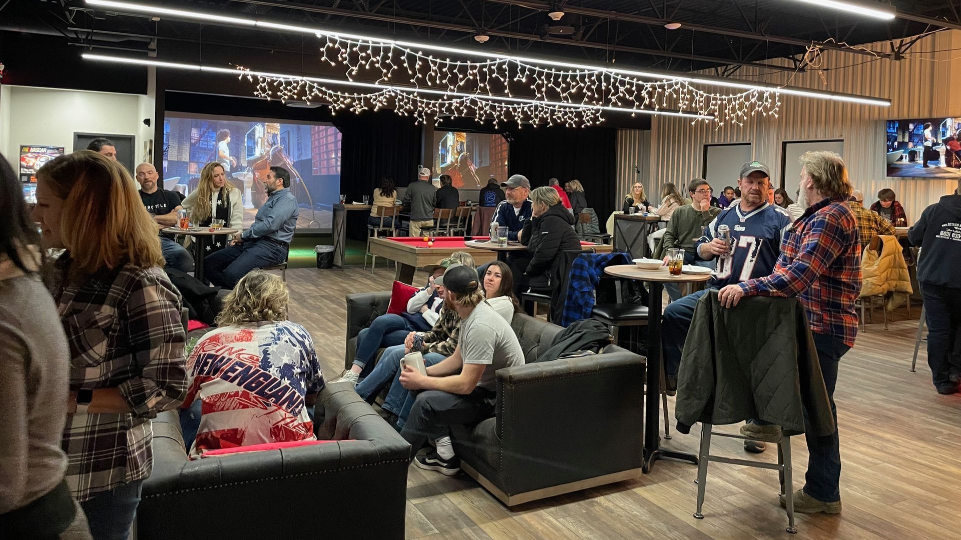 A group of people are sitting at tables in a large room.