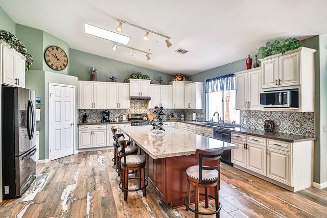 A large kitchen with a large island and a clock on the wall.