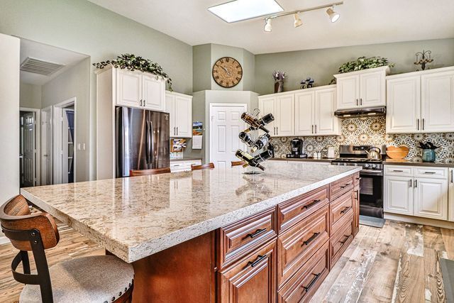 A kitchen with a large island and a clock on the wall.