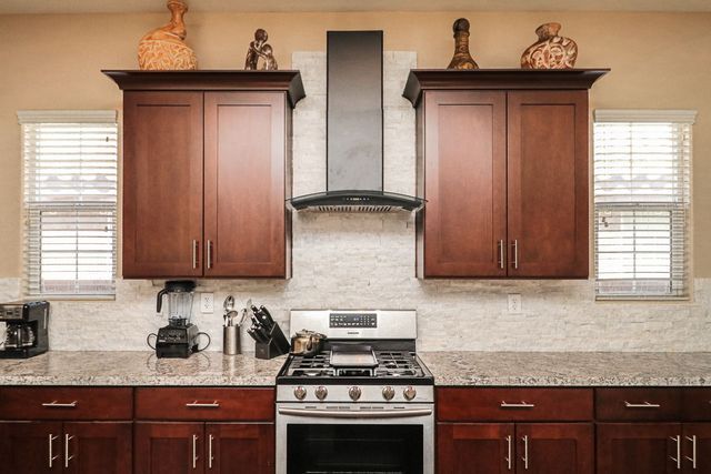 A kitchen with stainless steel appliances and wooden cabinets.
