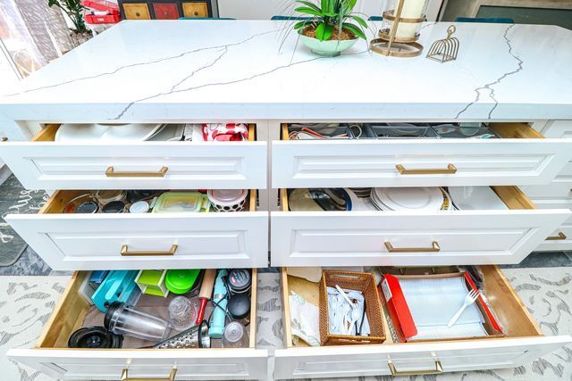A kitchen island with lots of drawers and a plant on top of it.