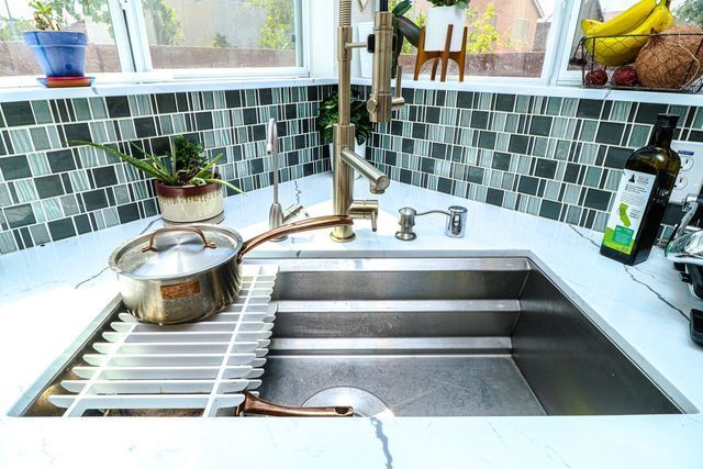 A kitchen sink with a pot and pan in it
