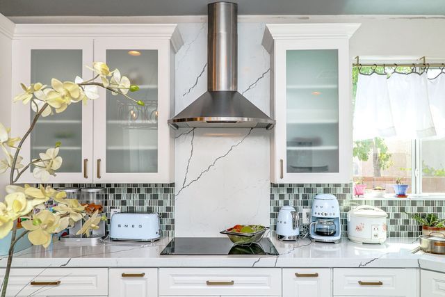 A kitchen with white cabinets and stainless steel appliances.