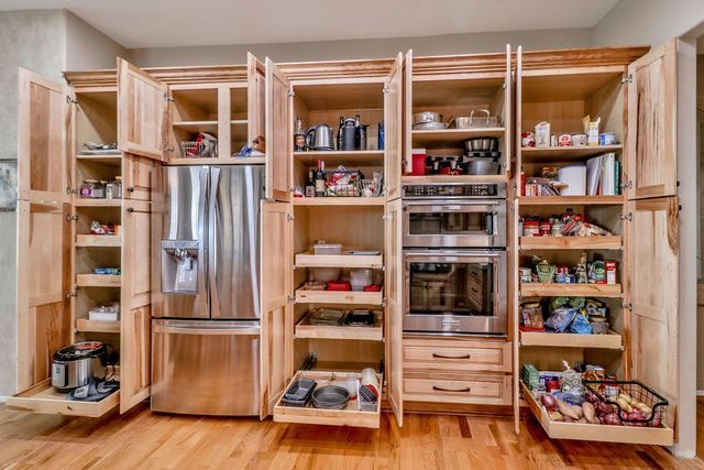 A kitchen with lots of cabinets and drawers and a refrigerator.