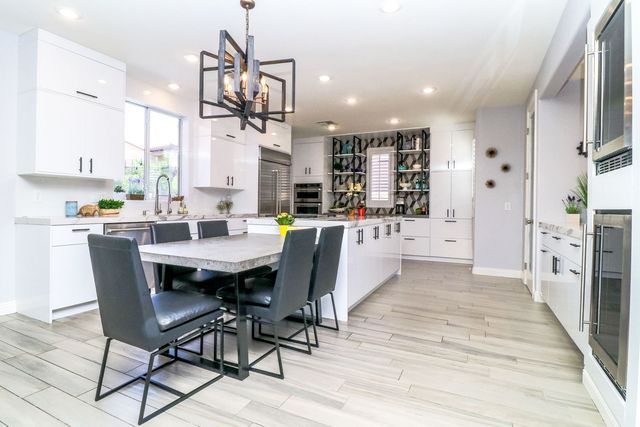 A kitchen with a dining table and chairs and a chandelier.