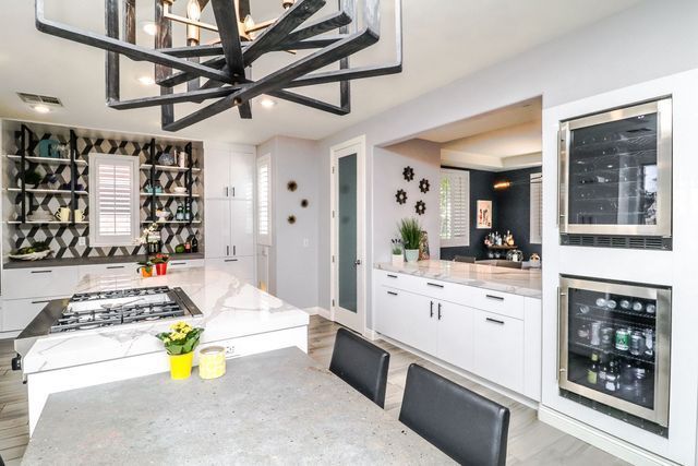 A kitchen with a table and chairs and a stove top oven.