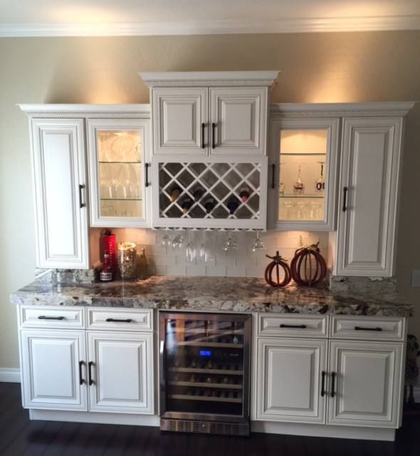 A kitchen with white cabinets and a wine cooler