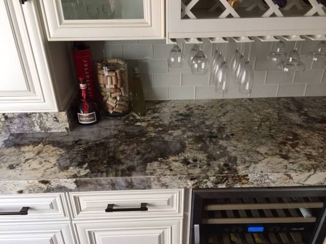 A kitchen counter with a wine cooler and a wine rack.