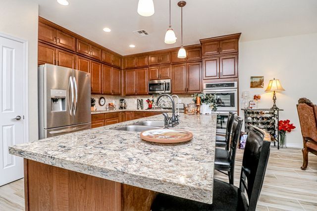 A kitchen with stainless steel appliances and granite counter tops.