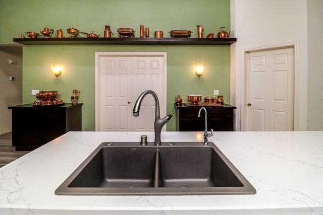 A kitchen sink is sitting on top of a white counter.