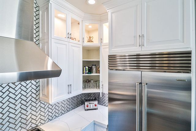A kitchen with white cabinets and stainless steel appliances.