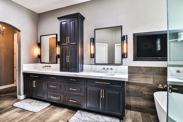 A bathroom with two sinks , two mirrors and a tub.