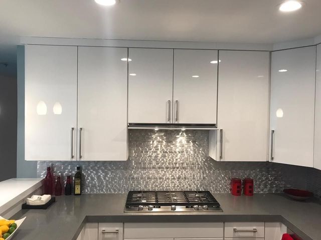 A kitchen with white cabinets and a stove top oven