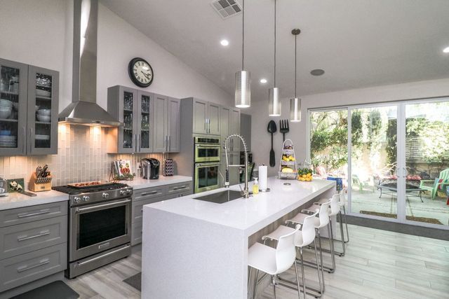 A kitchen with a large island and stainless steel appliances.