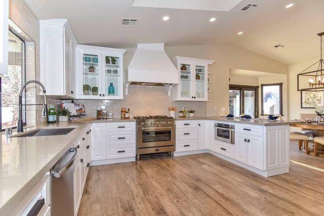A kitchen with white cabinets and stainless steel appliances