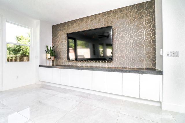 A living room with a flat screen tv mounted to the wall.