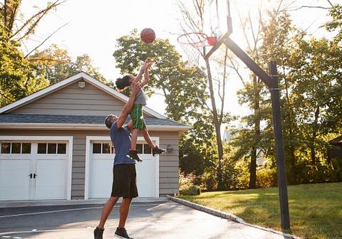 Driveways — Father And Son Playing Basketball On Driveway At Home in Greenleaf, WI