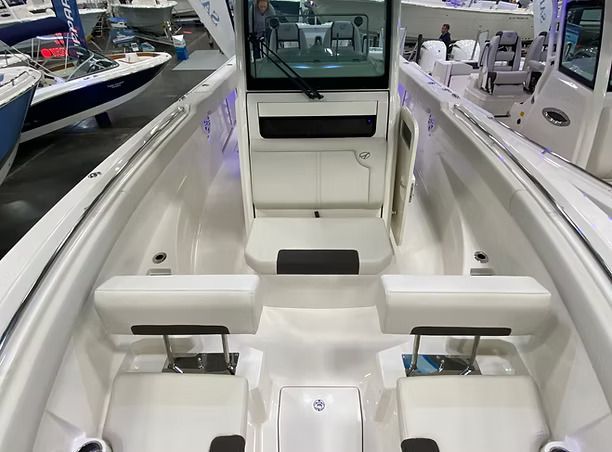 Inside of a white boat, featuring seating and a windshield.