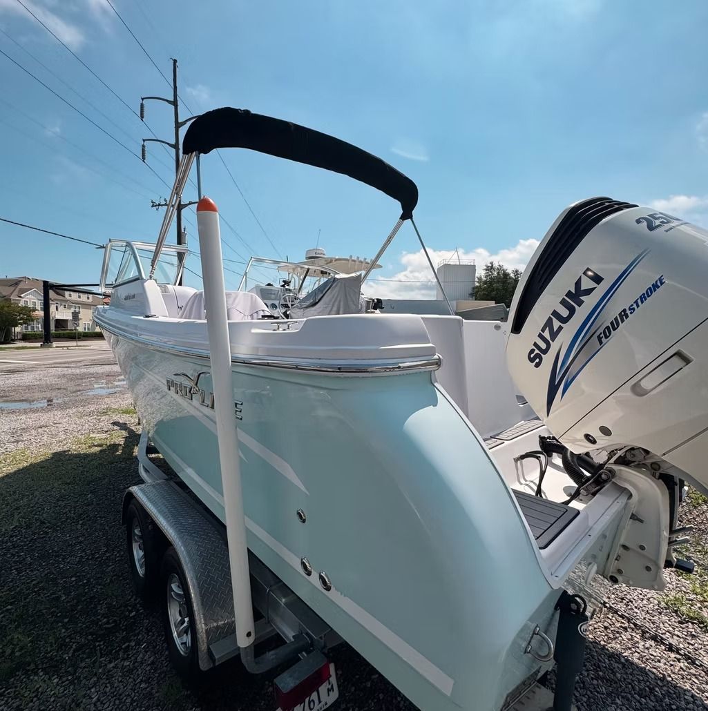 Light blue boat with a Suzuki engine on a trailer.