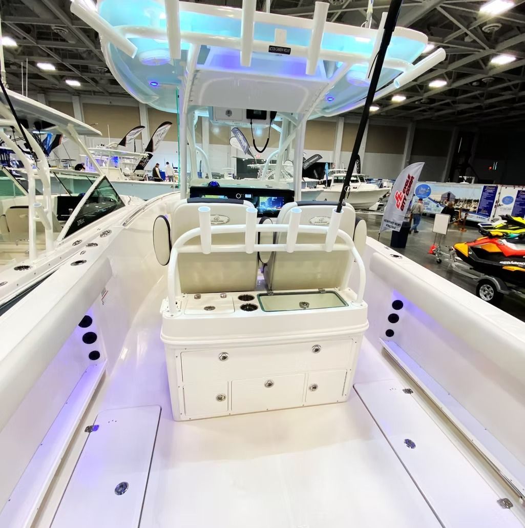 White fishing boat interior with white seating, console, and overhead structure; indoor setting.