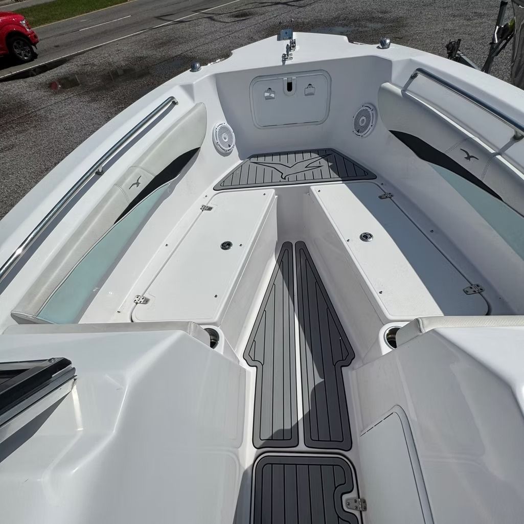 White boat interior with gray textured flooring, seating, and storage compartments.